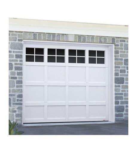 Close up on a white garage door with four rectangular windows with a grey brick house surround.